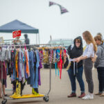 Shopping for vintage clothes at an outdoor market.